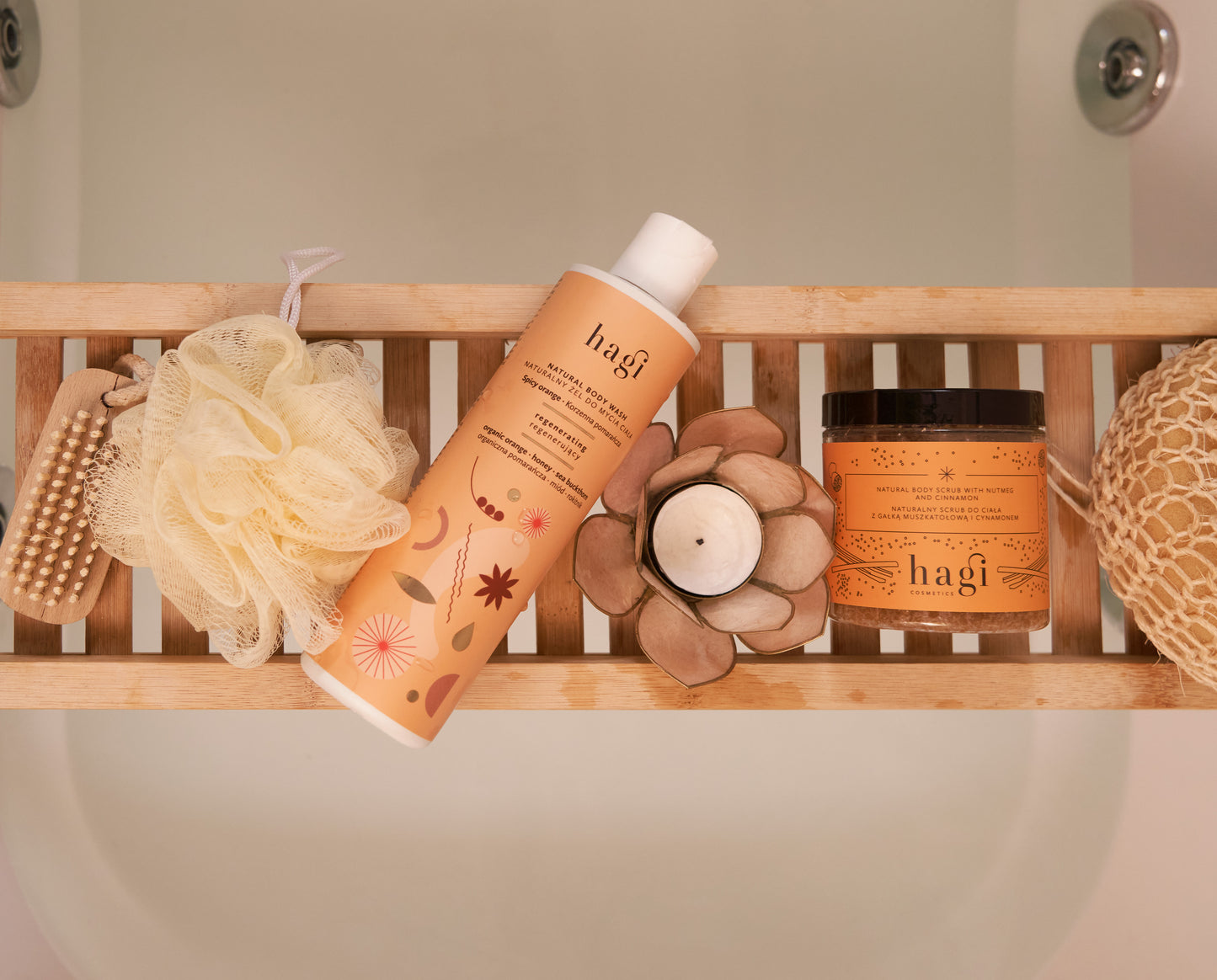 Produkty Hagi leżące na podpórce w łazience jest tu Naturalny Żel do Mycia Ciała Korzenna Pomarańcza 300ml oraz scrub Hagi korzenna pomarańcza 