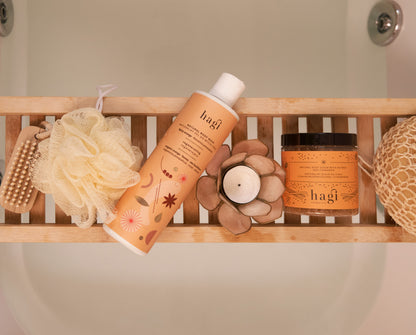 Produkty Hagi leżące na podpórce w łazience jest tu Naturalny Żel do Mycia Ciała Korzenna Pomarańcza 300ml oraz scrub Hagi korzenna pomarańcza 