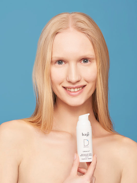 piękna, uśmiechnięta kobieta o naturalnym wyglądzie trzyma w dłoni Hagi SMART D Krem Nawilżająco-Kojący 50 ml