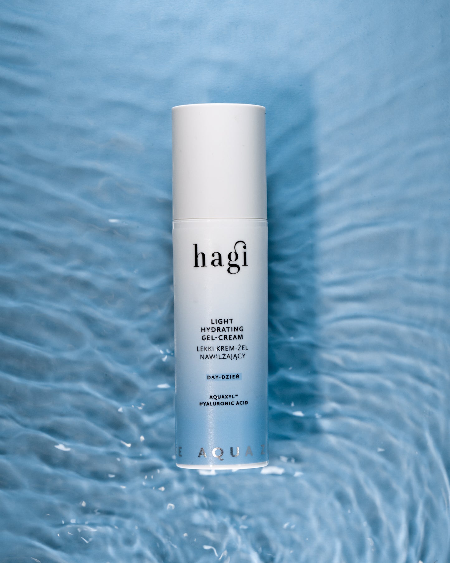 Hagi Aqua Zone Lekki Krem-Żel Nawilżający na Dzień 50 ml, który leży na tafli wody, co symbolizuje linię produktową aqua